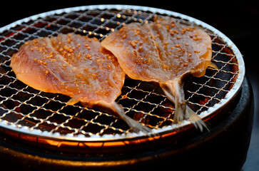 Dried grilled fish on a charcoal grill, in an izakaya.