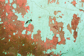 Grunge wall texture background. Paint cracking off dark wall with rust underneath