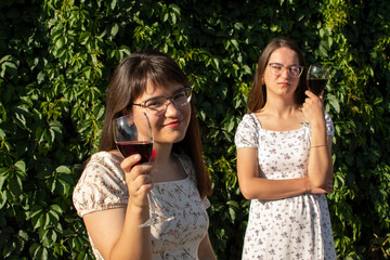 Portrait of a two young woman drinking wine	