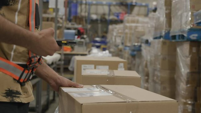 Warehouse worker scanning package box