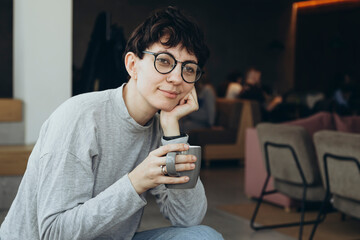 Sleepy young woman with a cup of coffee in the morning in the office.