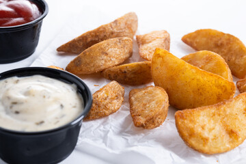 Fried potato wedges isolated on white background.