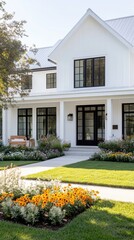 Obraz premium A charming white house with large windows and a welcoming porch, surrounded by vibrant flower beds and lush green grass.