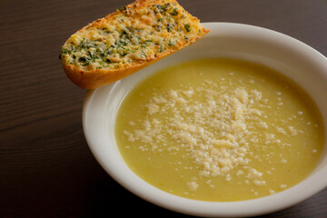 Zucchini Cream Soup with Parmesan and Garlic Bread Close-Up on Dark Background