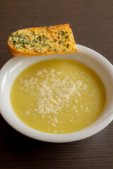 Zucchini Cream Soup with Parmesan and Garlic Bread Close-Up on Dark Background