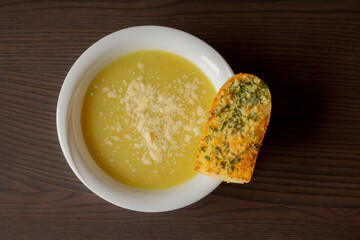 Zucchini Cream Soup with Parmesan and Garlic Bread Close-Up on Dark Background