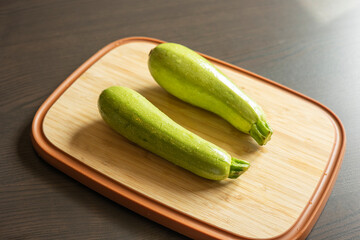 Two Fresh Zucchini on a Cutting Board Close-Up on Dark Background