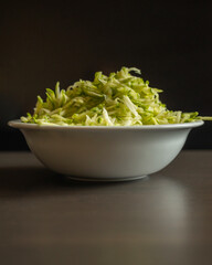  Shredded Zucchini in a White Bowl Close-Up on Dark Background