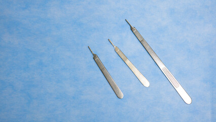 Stainless Medical instruments used for surgery placed on a blue background. Surgical instruments. Medical equipment. Medical science and surgery concept.