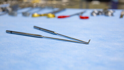 Surgical instruments hook retractor used for surgery placed on blue background with blurred...