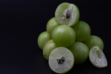 Macro shot of whole Amla also known as Indian gooseberry and sliced amla .
