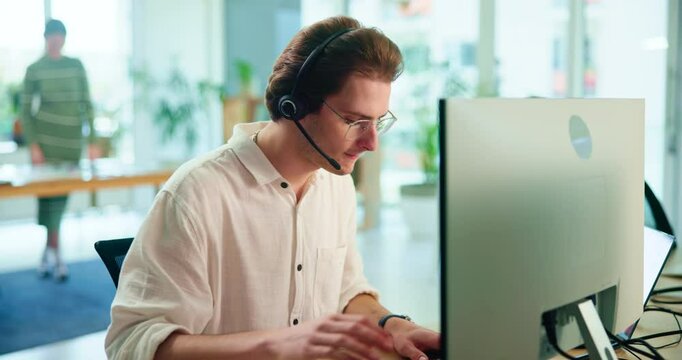 Man, call center and typing with computer in office with talking, reading or advice for tech support. Person, consultant or agent by pc, voip and crm with notes for customer care at telemarketing job