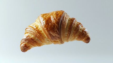   A close-up of a croissant in mid-air against a clear blue sky background