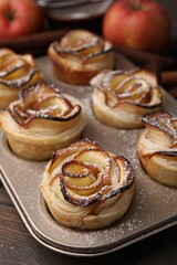 Freshly baked apple roses on wooden table, closeup. Puff pastry