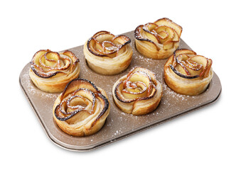 Freshly baked apple roses in cupcake pan isolated on white. Puff pastry