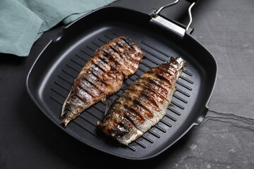 Delicious grilled mackerel in pan on dark textured table, closeup