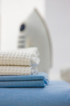 Close up of a stack of bed linen and an iron
