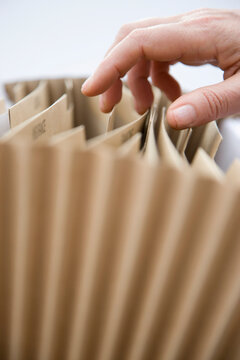 Close up of a man hand flicking through a file folder
