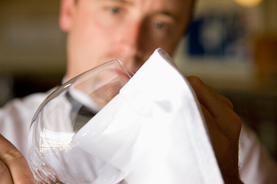 Waiter polishing a wine glass
