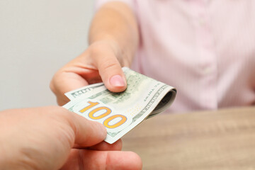 Cash turnover. Man gives banknotes to woman. Dollars. Close-up of hands with cash. Payment In Cash