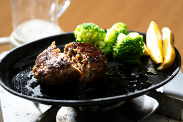 鉄板の上の熱々の焼きたてのビーフハンバーグ