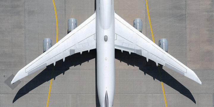 View from above white airplane on sunny airport tarmac
