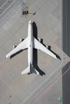 View from above airplane on sunny airport tarmac
