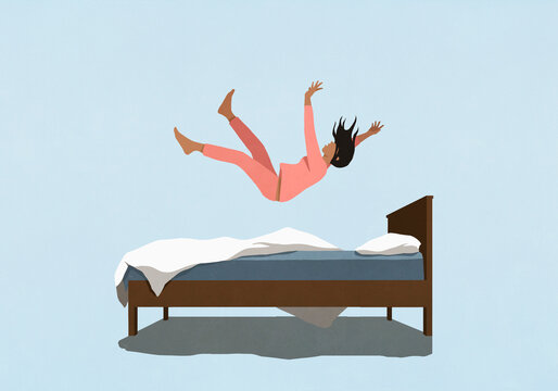 Woman in pajamas falling onto bed
