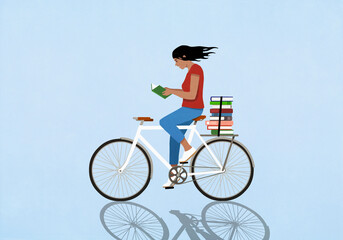 Woman reading book on bicycle against blue background

