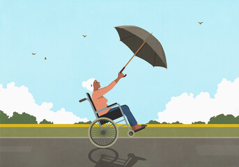 Senior woman in wheelchair using umbrella as sail in windy countryside
