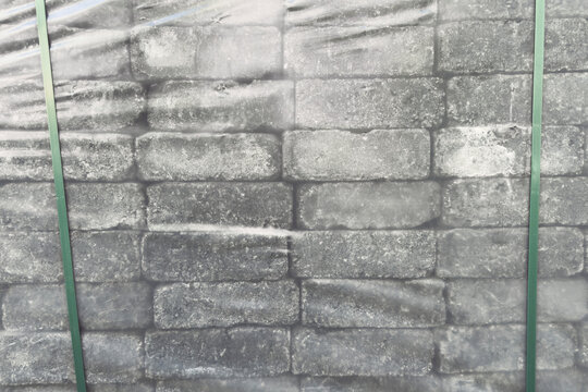 Close up stone pavers wrapped in plastic on pallet
