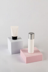 Plastic white tube for cream or lotion. Skin care or sunscreen cosmetic with stylish props on cream background.