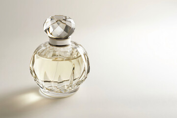 Crystal perfume bottle with a faceted glass stopper is standing on a white surface and casting a shadow