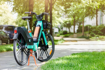 Bike Share Rental on Green Nature Background. Safe Electric Bicycle e bike on Bike Path. Eco Vehicle Sharing System.