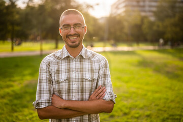 Portrait of happy adult man in park.