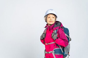 ヘルメットを被って歩くシニア女性の全身写真