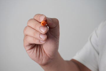 Male person hand holding pen writing, over grey
