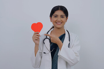 Happy Indian Female Doctor Holding Heart and Pointing at It