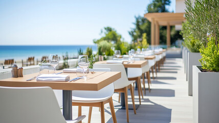 Fototapeta premium modern seaside restaurant terrace features empty chairs and tables, offering serene view of ocean. inviting atmosphere is perfect for dining and relaxation