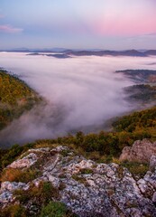 Autumn landscape with morning fog, with colorful autumn trees and rocks. Colorful autumn time with mountain hiking and foggy morning.