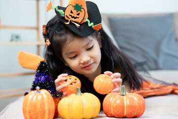 Adorable Child Enjoying Halloween with Pumpkins and Festive Decorations Indoors