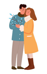 A couple in love in winter clothes are hugging and holding a branch with berries.Love couple at Christmas time.