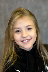Fototapeta premium a young girl with blonde hair and a black jacket.