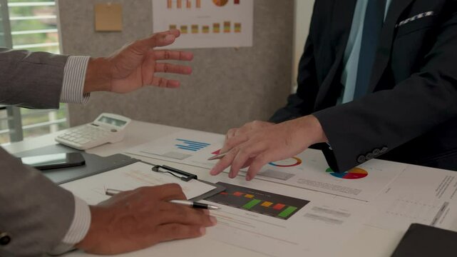 Architects and consultants of a housing development are discussing the structure and layout of a house,Two engineers are having a meeting about a problem that has arisen in the blueprints