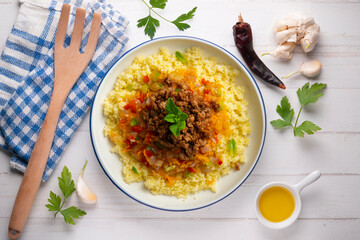 Couscous salad with vegetables and minced meat. Top view table with decoration.