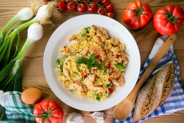 Couscous salad with vegetables and prawns. Top view table with  decoration.