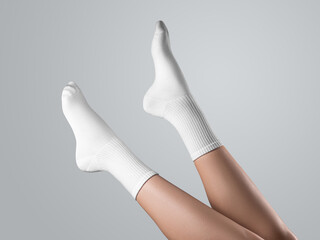 Mockup of white long socks on women's foot, with stretched toes, diagonal legs up presentation,...