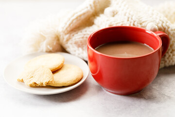 Red cup of delicious hot chocolate on white table background.