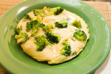 wholesome breakfast. omelet with broccoli on green plate