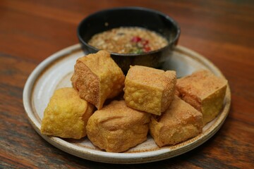 In Thailand, it is called fried tofu. The method of making it is to cut tofu into large pieces and then fry it. It is eaten with sweet sauce with peanuts and chili.